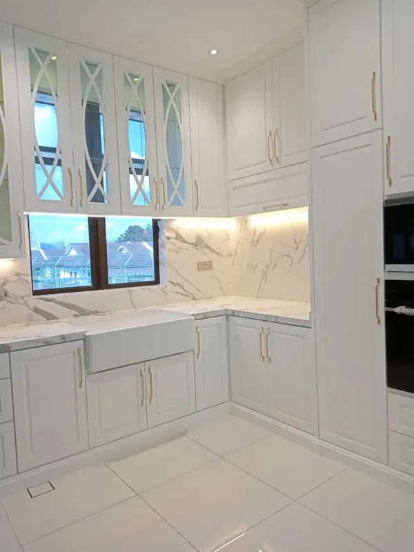 Completed white kitchen with arched glass cabinet doors and marble backsplash